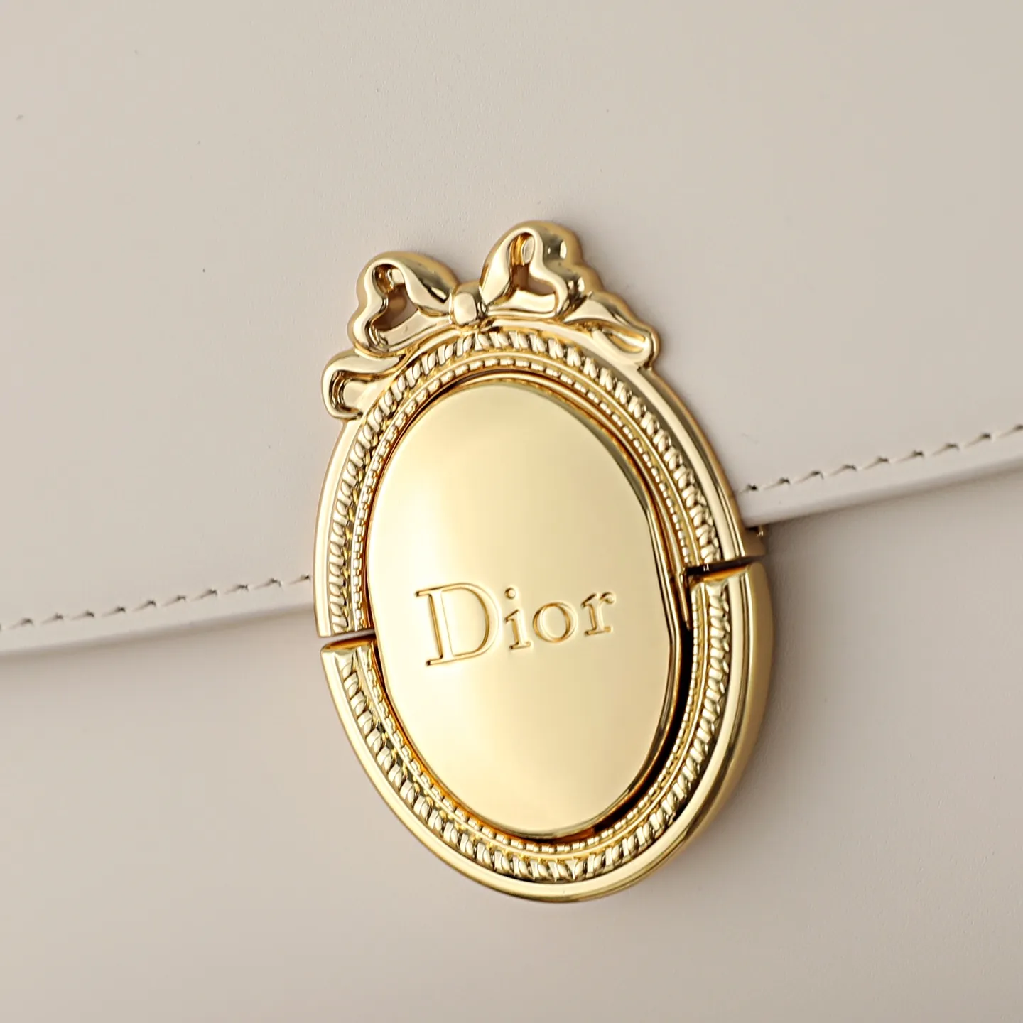 P700 原厂级 M&eacute;daillon 手拿包\n\n这款 Dior M&eacute;daillon 手拿包设计百搭，彰显 Dior 经久不衰的优雅风范。Dior M&eacute;daillon 标志扣环呼应 Dior 沙龙 18 世纪洛可可风格的优雅格调，缝有三角形衬料的挺括廓形则突显时髦气息。设有顶部手柄和可调节、可拆卸的链条，可手提或肩背突显高雅气质，可与日常造型或晚装搭配。\n\nM3671\n尺寸：26 x 11.5 x 4.5 厘米（长 x 高 x 宽）