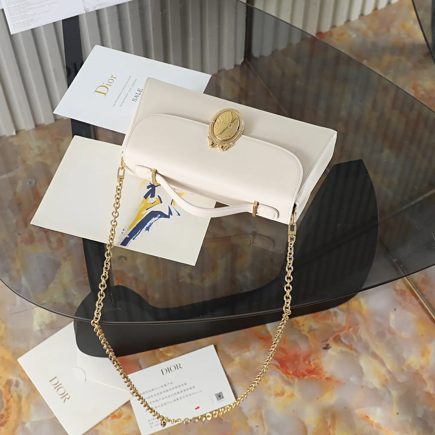 P700 原厂级 M&eacute;daillon 手拿包\n\n这款 Dior M&eacute;daillon 手拿包设计百搭，彰显 Dior 经久不衰的优雅风范。Dior M&eacute;daillon 标志扣环呼应 Dior 沙龙 18 世纪洛可可风格的优雅格调，缝有三角形衬料的挺括廓形则突显时髦气息。设有顶部手柄和可调节、可拆卸的链条，可手提或肩背突显高雅气质，可与日常造型或晚装搭配。\n\nM3671\n尺寸：26 x 11.5 x 4.5 厘米（长 x 高 x 宽）